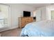 Bedroom with a wood dresser with a TV and a view into the bathroom with a glass shower at 23 Fairway Rd, Rotonda West, FL 33947