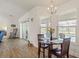 Cozy dining area with wood floors, a round table, and sliding glass doors leading to the pool area at 23 Fairway Rd, Rotonda West, FL 33947