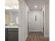 Hallway with a view into a bathroom with gray cabinets, granite countertop, and a walk-in shower at 23 Fairway Rd, Rotonda West, FL 33947
