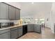 Kitchen features granite countertops, gray cabinets, black appliances, and dining area at 23 Fairway Rd, Rotonda West, FL 33947