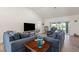 Inviting living room with comfortable seating, wood-look tile flooring, and sliding glass doors to the lanai at 23 Fairway Rd, Rotonda West, FL 33947