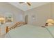 Inviting bedroom with a comfortable bed, ceiling fan, wooden furniture, and neutral color scheme at 26636 Irwin Dr, Englewood, FL 34223