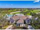 Aerial view of the gorgeous clubhouse overlooking meticulously maintained golf course and surrounding mature trees at 26636 Irwin Dr, Englewood, FL 34223