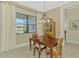 Bright dining room with natural light, wood table, and views of green space at 26636 Irwin Dr, Englewood, FL 34223