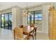Dining room with wood furniture, elegant curtains, and a large window at 26636 Irwin Dr, Englewood, FL 34223