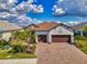 Charming single-story home boasts a tile roof, paver driveway and lush landscaping at 26636 Irwin Dr, Englewood, FL 34223