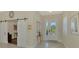 Bright foyer with a sliding barn door entry and a welcoming entryway table at 26636 Irwin Dr, Englewood, FL 34223
