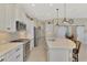 Bright kitchen with stainless steel appliances, white cabinetry, and a large center island at 26636 Irwin Dr, Englewood, FL 34223