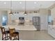 Bright kitchen with stainless steel appliances, white cabinetry and an island with seating at 26636 Irwin Dr, Englewood, FL 34223