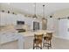 Contemporary kitchen features pendant lighting, stainless appliances, white cabinets, and bar stool seating at 26636 Irwin Dr, Englewood, FL 34223