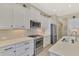 Modern kitchen with stainless steel appliances, quartz countertops and white cabinetry at 26636 Irwin Dr, Englewood, FL 34223
