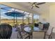 This screened-in patio includes plenty of seating, ceiling fan, and a view of the landscape at 26636 Irwin Dr, Englewood, FL 34223