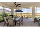 Relaxing screened-in patio with beautiful views, ceiling fan, and outdoor furniture at 26636 Irwin Dr, Englewood, FL 34223