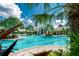 Stunning community pool with a clubhouse surrounded by lush tropical landscaping and plenty of lounge seating at 26636 Irwin Dr, Englewood, FL 34223