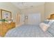 Bedroom featuring rattan furniture, a dresser, and a view into the home's hallway at 27413 Hole In One Pl, Englewood, FL 34223