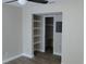 Bedroom closet featuring wood-look tile, neutral walls, and built in shelves at 5055 N Beach Rd # 203, Englewood, FL 34223
