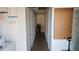 Hallway features multiple closet doors, laundry instructions and washer, and in need of clean up and repair at 5055 N Beach Rd # 203, Englewood, FL 34223