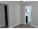 Hallway showing entry into a room featuring neutral walls and wood-look tile floors at 5055 N Beach Rd # 203, Englewood, FL 34223