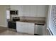 Kitchen with white cabinets, granite countertops, and stainless steel appliances at 5055 N Beach Rd # 203, Englewood, FL 34223