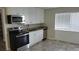 Kitchen with white cabinets, stainless steel appliances, and granite countertops at 5055 N Beach Rd # 203, Englewood, FL 34223