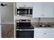 Kitchen with white cabinets, stainless steel appliances, and granite countertops at 5055 N Beach Rd # 203, Englewood, FL 34223