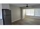 Bright living room featuring wood-look tile, neutral walls, and a modern ceiling fan at 5055 N Beach Rd # 203, Englewood, FL 34223