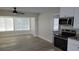 Living room with tile floors, fan, and windows for natural light at 5055 N Beach Rd # 203, Englewood, FL 34223