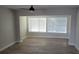 Living room featuring wood-look tile, neutral walls, and large, bright windows at 5055 N Beach Rd # 203, Englewood, FL 34223
