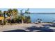 Amazing water view with a swing and palm trees provides a relaxing escape by the shore with calm waters at 5055 N Beach Rd # 203, Englewood, FL 34223