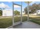 View of backyard from screened-in porch. Features include a shed and a well manicured lawn at 6347 Oriole Blvd, Englewood, FL 34224