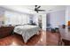 Bright bedroom featuring hardwood floors, a ceiling fan, and a view into a connected workspace and bathroom at 6347 Oriole Blvd, Englewood, FL 34224