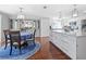 Bright dining area with a table and chairs adjacent to a modern kitchen with white cabinets and a marble countertop island at 6347 Oriole Blvd, Englewood, FL 34224