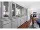 Dining area featuring updated gray cabinets with a buffet, glass storage, and adjacent updated kitchen at 6347 Oriole Blvd, Englewood, FL 34224