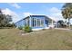 Quaint blue house featuring a well-kept lawn and large windows at 6347 Oriole Blvd, Englewood, FL 34224