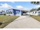Charming blue home with a covered carport and well-maintained landscaping at 6347 Oriole Blvd, Englewood, FL 34224