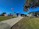 Charming blue home with an American flag, covered carport, and well-maintained landscaping at 6347 Oriole Blvd, Englewood, FL 34224