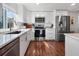 Modern kitchen featuring stainless steel appliances, white cabinets, and hardwood floors at 6347 Oriole Blvd, Englewood, FL 34224