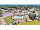 Aerial view of the community featuring a swimming pool, clubhouse, and pond surrounded by trees at 6522 Coliseum Blvd, Port Charlotte, FL 33981