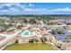 Aerial view of the community clubhouse, pool, and surrounding neighborhood with lush landscaping at 6522 Coliseum Blvd, Port Charlotte, FL 33981
