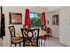 Cozy dining area with a round table, four chairs, red curtains, and view of the lush backyard at 6522 Coliseum Blvd, Port Charlotte, FL 33981