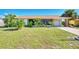 Charming single-story home with mature landscaping and covered parking on a sunny day at 6522 Coliseum Blvd, Port Charlotte, FL 33981