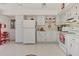 Bright kitchen with white appliances, cabinetry, neutral tile flooring and adjacent dining nook at 6522 Coliseum Blvd, Port Charlotte, FL 33981