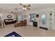 Bright living room with tile flooring, ceiling fans, and a decorative front door, offering a welcoming atmosphere at 6522 Coliseum Blvd, Port Charlotte, FL 33981