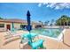 Community pool area with lounge chairs, tables, and umbrellas at 6522 Coliseum Blvd, Port Charlotte, FL 33981