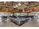 Large recreation room featuring pool tables, wood beamed ceiling, fans, and stone accents at 6522 Coliseum Blvd, Port Charlotte, FL 33981