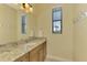 Modern bathroom vanity with a granite countertop, wood cabinets, and decorative mirror at 72 Pennant Ct, Placida, FL 33946