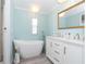 Luxurious bathroom featuring a freestanding tub, dual sinks, and a stylish chandelier for elegance at 8243 Pinetree Ln, Englewood, FL 34224