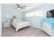 Bright bedroom features new flooring, ceiling fan, and tranquil light blue walls at 8243 Pinetree Ln, Englewood, FL 34224