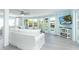 Airy living room boasts neutral tones, comfortable seating, and expansive windows with views of the pool at 8243 Pinetree Ln, Englewood, FL 34224