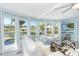 Bright living room featuring a sofa, glass table, and large windows overlooking the pool and outdoor space at 8243 Pinetree Ln, Englewood, FL 34224